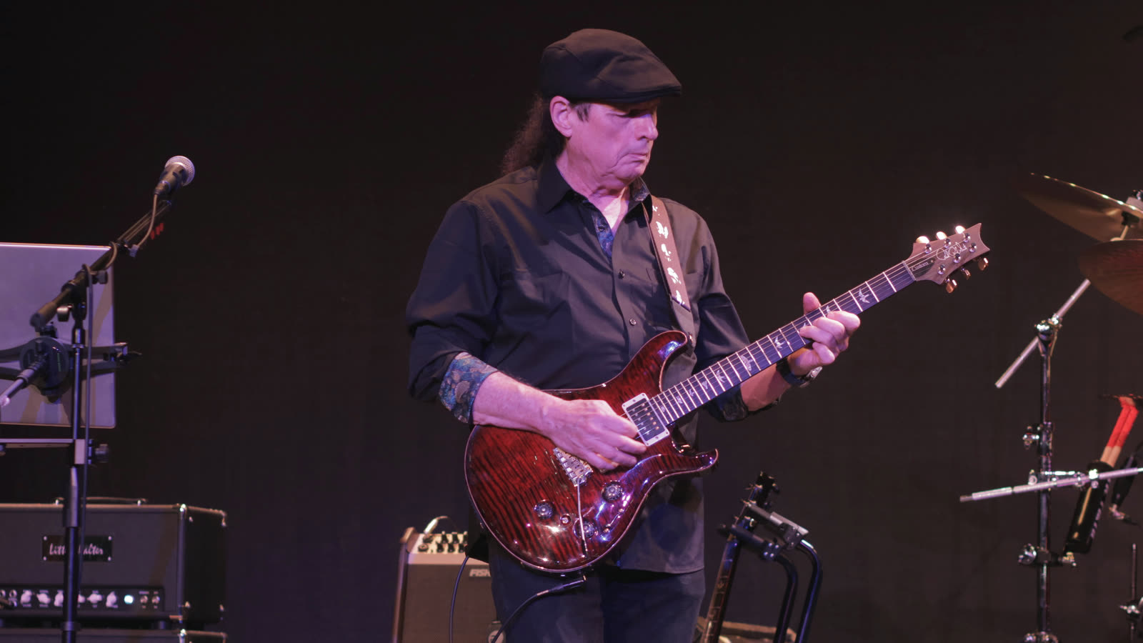 Allen playing a cherry-red electric guitar.