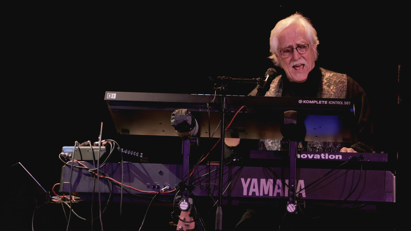 Rico singing, with his keyboards in front of him.