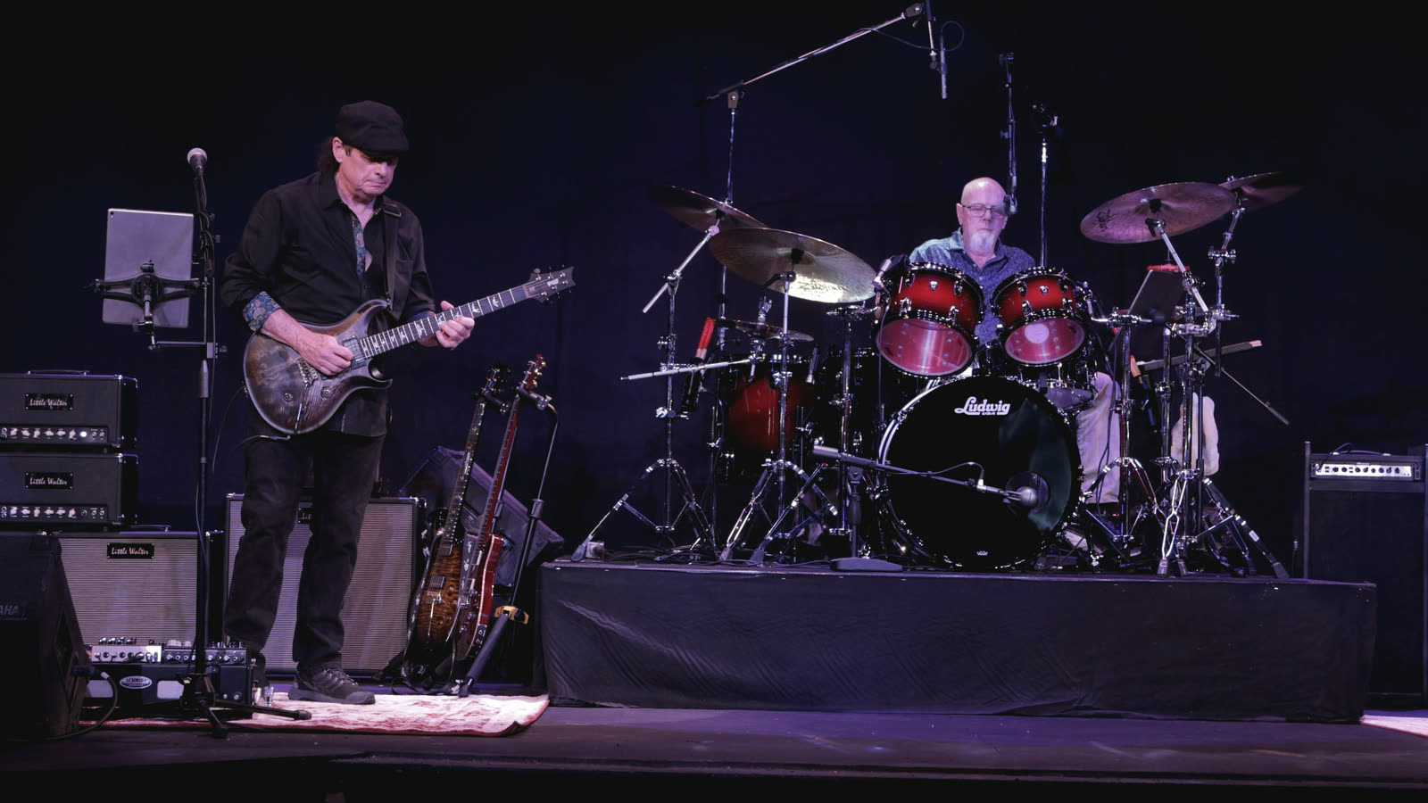Allen on guitar at left, with Ed at his drum kit on a riser.